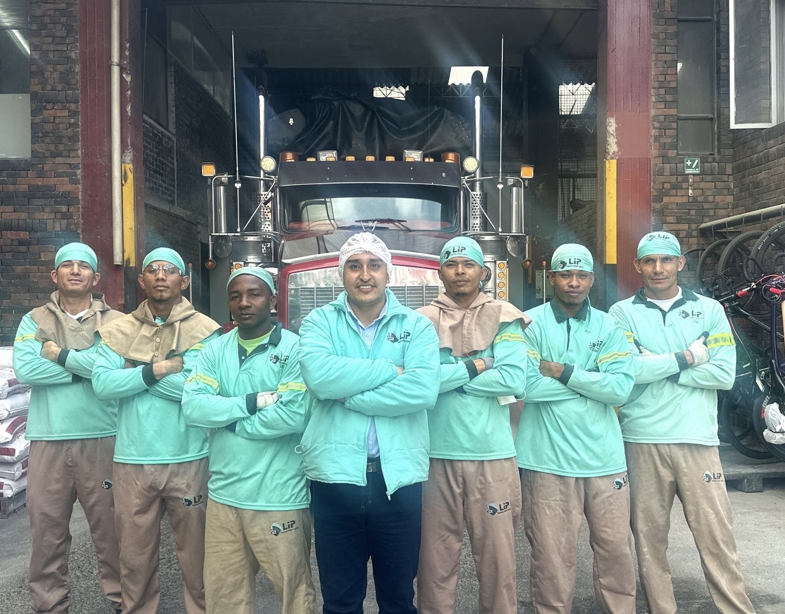 Equipo profesional de LIP frente a camión de carga en instalaciones logísticas